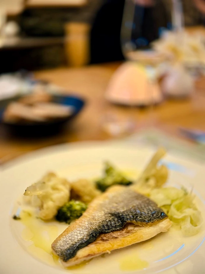 Plat gastronomique de poisson accompagné de légumes, préparé par le chef Sébastien Beauquenne.